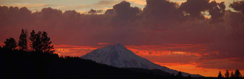 This is a picture of a mountain with the sun- setting in the background.